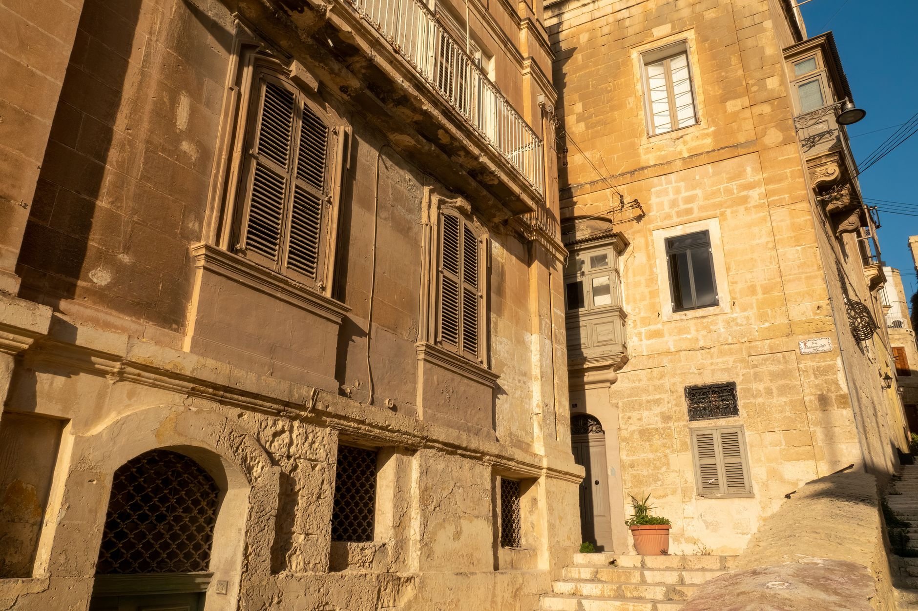 Beautiful sunlit view of traditional limestone buildings in Malta.
